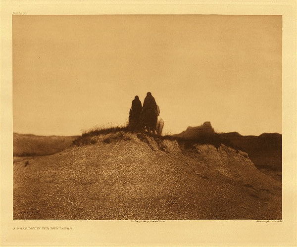 Edward S. Curtis - *50% OFF OPPORTUNITY* Plate 086 A Gray Day in the Bad Lands - Vintage Photogravure - Portfolio, 18x22 inches - Description by Edward S. Curtis: “A cold, cheerless day, when the party of Sioux, wrapped closely in their blankets, rode in stolid silence. An Original photogravure produced in Boston by John Andrew & Son. Taken by Curtis is 1905 in the Badlands of South Dakota and Nebraska.” <br> <br>Curtis was largely self-taught in photography, but would go on to win numerous awards and become the friend and associate of the presidents, kings, titans of business and industry, and important tribal leaders throughout the Western United States and Canada. His subscribers were the most wealthy people of his time.