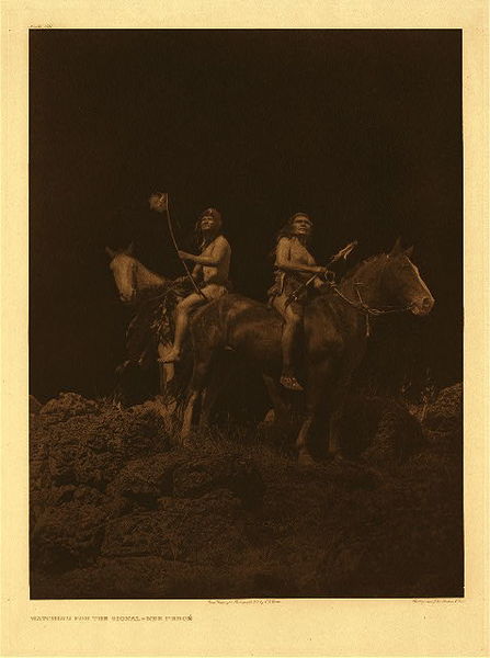 Edward S. Curtis - Plate 261 Watching for the Signal - Nez Perce - Vintage Photogravure - Portfolio, 22 x 18 inches - This image is a rare nocturne taken by Edward Curtis. The photogravure depicts two men on horseback. The picture is taken from below and makes the men look almost God-like in presence. <br> <br>"The Nez Perces were primarily a fish eating people living in established villages, but they also depended largely on the many varieties of roots which were so abundant in their inter-montane region. It is likely that they went to buffalo country little, if at all, previous to their acquisition of horses, and even after that event but a small part of the tribe engaged in these hunting expeditions." - Edward Curtis
