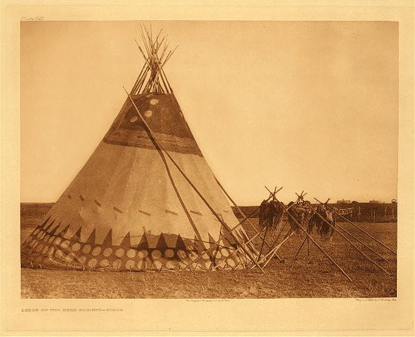 Edward S. Curtis - Plate 645 Lodge of the Horn Society - Blood - Vintage Photogravure - Portfolio, 18 x 22 inches - Because the Blackfoot, Blood and Piegan tribes are so culturally intertwined, the same description is used for their tipis. <br> <br>From Volume 18: Their tents are large and clean. The devices generally used in painting them are taken from beasts and birds; the buffalo and the bear are frequently delineated. <br> <br>The country they inhabit abounds with animals of various kinds; beaver are numerous, but they will not hunt them with any spirit, so that their principal produce is dried provisions, buffalo robes, wolves, foxes, and other meadow skins, and furs of little value.