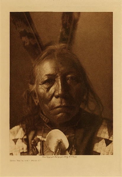 Edward S. Curtis - Ring Thunder - Brule - Vintage Photogravure - Volume, 12.5 x 9.5 inches - Born 1840. At eighteen accompanied a party under Knife, against the Pawnee. He himself led twenty-three war-parties, all against the same tribe. He counted coup once, was never wounded, nor did an enemy ever strike him. <br> <br>Ring Thunder was 67 when he had this photograph taken by Edward S. Curtis. Born in 1840 he was an accomplished warrior and led 23 war parties. He was never wounded in battle or even ever hit by an enemy. When he was 33 he was elected chief of the Brule tribe. <br> <br>This photogravure was taken in 1907 by Edward S. Curtis. The piece was printed on Dutch Van Gelder and is available for sale in out Aspen Art Gallery.
