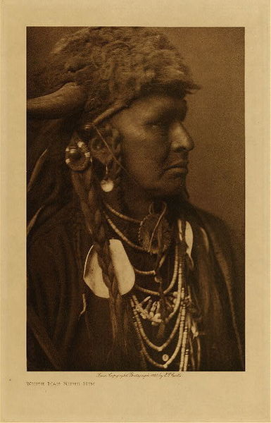 Edward S. Curtis - White Man Runs Him (Portrait) (One of Custer’s Crow Scouts) - Vintage Photogravure - Volume, 12.5 x 9.5 inches - Born about 1854 or 1855. Mountain Crow; Big Lodge clan; Lumpwood organization. His only coup was counted by the capture of a tethered horse. Noted for his many successful horse-raiding expeditions against the Sioux. <br>Scouted with Custer in his last campaign, and was one of the party of three or four scouts who, at the dawn of the morning of the Custer fight, first sighted the Sioux camp. A small party of Crow and Arikara scouts under Lieutenant Varnum, having traveled nearly all night, arrived shortly before dawn almost a the summit of the highest peak in the Wolf mountains, where the party slept for a short time. At approaching light White Man Runs Him and a couple of companions went to the top of the high peak which gave them the first view of the Sioux encampment. Following Custer's coming up to view the valley and its camp of hostiles, he was with Custer until the Sioux made their attack on him. White Man Runs Him's recollections of that day are exceedingly clear. The author spent several days with him traveling carefully over the ground covered on the day of the disastrous fight on the Little Bighorn, part of this time being accompanied by general C.A. Woodruff. <br>White Man Runs Him possesses no medicine derived from his own vision, but once fasted four days and four nights in the Bighorn mountains on a peak known to the Apsaroke as "Where White Man Runs Him Fasted." Of his seven wives he gave up six "good ones," that is, those who had borne him children; to discard such was an indication of a strong heart.
