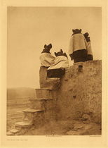 Edward S. Curtis - *50% OFF OPPORTUNITY* Plate 405 Watching the Dancers - Vintage Photogravure - Portfolio, 22 x 18 inches - Four young Hopi girls have their backs to the camera. Wearing traditional holiday dress they are watching dancer from a nearby rooftop. The adobe structure is simple, yet sturdy.
<br>
<br>Description by Edward Curtis: A group of girls on the topmost roof of Walpi, looking down into the plaza.
<br> 
<br>"The Hopi reservation was established in 1882, but until the beginning of the twentieth century the people were practically independent of governmental authority. Since that time official supervision, assistance, and sometimes blundering interference in harmless religious and personal customs, has become more and more effective, and the result is the gradual abandonment of the old order. In 1906 not a maid at the East mesa kept her hair in the picturesque squash-blossom whorls indicative of the unmarried state." - Edward Curtis