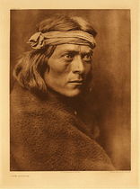 Edward S. Curtis - Plate 607 A Zuni Governor - Vintage Photogravure - Portfolio, 22 x 18 inches - This man appears to be of middle age and is considered a Zuni governor. His appearance is typical of Zuni people. He stares intently into the distance looking as if he is planning great things. He wears a dark brown blanket and a cloth headband. This photogravure was taken by Edward S. Curtis in 1926, nearing the end of his massive project, “The North American Indian”. Printed on Dutch Van Gelder Paper, this image is on display in our Aspen Art Gallery.