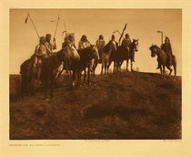Edward S. Curtis - Plate 116 Watching for the Signal - Apsaroke - Vintage Photogravure - Portfolio, 18 x 22 inches - When there were indications that the war-party was near the enemy, a halt was made while the scouts reconnoitered the position of the hostile party. Their appearance on a distant hilltop was awaited by the main body with great anxiety, for if they were seen running in zigzag lines it meant that the enemy had been actually discovered. - Edward Curtis
<br>
<br>The chief rides off a short distance in the direction they are to go,
<br>and some of his old men sit about him smoking and talking. Then
<br>they move forward a distance and halt while the people complete
<br>their preparations for the march. Now the line begins to form —
<br>first the chiefs and old men; then a band of arrogant, gayly dressed
<br>Lumpwoods, with newly stolen wives riding behind and carrying
<br>their husbands’ shields and lances; next a body of clansmen with a
<br>group of proud young wives bedecked in all their fi nery. Behind them
<br>the column continues to form, family by family, each driving its herd
<br>of horses, until at length come straggling by those who have been
<br>slow in packing. A moving column of six hundred lodges is miles in
<br>length and of a width determined by the groups of families or by the
<br>nature of the country traversed. When they near the place the chief has
<br>designated for the night’s camp, many of the grandfathers ride ahead
<br>and select spots for their own lodges, clear the ground, and gather dry
<br>wood. As the irregular line drags in, they stand beside their chosen
<br>places, calling out to their wives where to come. If the weather be
<br>cold, they already have kindled small fires, and now take down the
<br>little children from the tops of the packs and hold them in the warmth
<br>of the leaping flames. A splendid picture of the nomads’ life they made as the caravan moved across far-reaching plain, hill, and valley. The crossing of a broad stream added much to the animation of the scene.
<br>
<br>One summer, nine hundred and fifty lodges of Apsaroke went to the Yellowstone, intending to cross. As the water was very high and the river nearly half a mile in width, the Kick Bellys, numbering four hundred and fifty lodges, lost their courage, and would not attempt the crossing.
<br>All the others, however, were unafraid and passed over. They used
<br>no boats, but made small rafts of driftwood, laying the ends of the
<br>lodge-poles on these rude craft, and allowing the tops to float on the
<br>water behind. On the poles a large piece of old lodge-covering was
<br>spread, and on that were piled the domestic belongings, the edges of
<br>the skin being gathered up and tied at the top to protect the load from
<br>splashing water. Perched upon this bundle rode the old women and
<br>the children. Two young men grasped the manes of strong swimming
<br>horses and swam along by their side, towing the raft across. Behind,
<br>holding to the ends of the lodge-poles, swam the young women and
<br>maidens, clad only in a short skirt reaching from waist to knee. It
<br>was a time of great merriment and fun-making, yet one not without
<br>its serious side, for a tottering old woman gazed long at the swirling
<br>river and, declaring that she was not afraid to die but feared the water,
<br>stabbed herself and fell lifeless. The crossing occupied four days, for
<br>the current was swift, and many who had no horses were compelled
<br>to wait for assistance from their relatives. Before going into the water
<br>men and women painted red stripes about waist, wrists, and ankles, for
<br>protection against the water-monsters that were believed to inhabit all
<br>large streams. Necklaces of white beads were never worn in the water, for beads of that sort were believed to be hailstones, the symbol of the Thunderbird, a deadly enemy of water-monsters, which therefore
<br>would be glad to swallow any one thus showing his friendship with
<br>the Thunderbird.