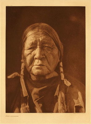 Edward S. Curtis - Plate 684 Uwat - Comanche - Vintage Photogravure - Portfolio, 18 x 22 inches - Throughout “The North American Indian”, Curtis used published sources and they added to his field research. Drawing upon other sources was crucial for discussing the Comanche as Curtis and his assistants encountered difficulties in gathering information. He quoted from an 1852 essay by Robert S. Neighbors. Neighbors served as a government agent for Indian matters in Texas. Neighbors wrote, “The women perform all manual labor.” He cited “war and hunting being all the occupation of the men.”