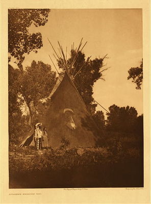 Edward S. Curtis -   Plate 141 Apsaroke Medicine Tipi - Vintage Photogravure - Portfolio, 22 x 18 inches - This image was taken by photographer Edward S. Curtis in 1909 and depicts a large Apsaroke Tipi. The tipi belonged to a medicine man who is pictured standing to the right of the structure. The Crow tribes were known to construct some of the largest tipis of all of the plains tribes and often tipis would be adorned inside and out with special imagery that was meaningful to the person or family who inhabits it.
<br>
<br>Medicine men also used specific designs to adorn their tipis but they were specifically painted according to the medicine man’s visions. Medicine men would most likely receive visions while fasting. This particular tipi is painted dark red and also has various symbols on the covering. According to Edward Curtis in his North American Indian, no man would dare so to decorate a tipi without having received his instructions in revelation from the spirits.
<br>
<br>This photograph was taken in 1909 and was printed on Dutch Van Gelder paper. The piece is now for sale at our Aspen Art Gallery.
