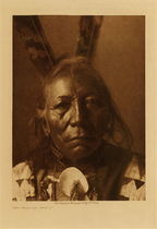 Edward S. Curtis -   Ring Thunder - Brule - Vintage Photogravure - Volume, 12.5 x 9.5 inches - Born 1840. At eighteen accompanied a party under Knife, against the Pawnee. He himself led twenty-three war-parties, all against the same tribe. He counted coup once, was never wounded, nor did an enemy ever strike him. 
<br>
<br>Ring Thunder was 67 when he had this photograph taken by Edward S. Curtis. Born in 1840 he was an accomplished warrior and led 23 war parties. He was never wounded in battle or even ever hit by an enemy. When he was 33 he was elected chief of the Brule tribe.
<br>
<br>This photogravure was taken in 1907 by Edward S. Curtis. The piece was printed on Dutch Van Gelder and is available for sale in out Aspen Art Gallery.