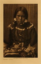 Edward S. Curtis - *50% OFF OPPORTUNITY* Kalispel Maiden - Vintage Photogravure - Volume, 12.5 x 9.5 inches - IN this Edward Curtis photo a young Kalispel girl looks into the camera. She is wearing a beautiful dress adorned with elk teeth. Her hair is braided down both sides of her face and she has earrings on as well. This photogravure was taken by Edward S. Curtis in 1910 and was printed on Dutch Van Gelder Paper. Curtis used this image for his 3rd volume of the North American Indian and it is now available for sale in our Aspen Art Gallery.