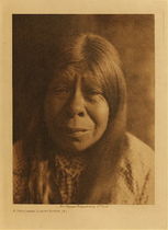 Edward S. Curtis - *50% OFF OPPORTUNITY* A Chukchansi Yokuts Woman - Vintage Photogravure - Volume, 12.5 x 9.5 inches - Primitive Foods - In the hill country acorns and other nuts, seeds of grasses, sage, and other small plants, fruits, and various roots and green stalks were important articles of food. Many of the valley dwellers were far removed from the oaks and other food producing trees and shrubs, and depended largely on tule-roots, small seeds, and fish. In the region of Tulare lake large quantities of fish were dried. In winter the San Joaquin plain swarmed with deer, antelope, and elk, but the Yokuts were not adept at hunting. The usual method was to drive the animals past an ambush. Rabbits, ground-squirrels, and small birds were of more importance than the ruminants. - Edward S. Curtis