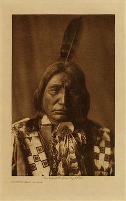 Edward S. Curtis -   Spotted Elk - Brule - Vintage Photogravure - Volume, 12.5 x 9.5 inches - First war-party at seventeen. It was said of him, as of any able-bodied male who waited so long before engaging in war that "he slept too long." At the first night's camp, to try his strength of heart, he was sent back to the starting point (the party traveled afoot) to bring water; he returned at daybreak with a buffalo-paunch full of water. He took an active part in the battle and was shot through the leg. Five Apsaroke scalps were taken, and four Sioux wounded. 
<br>
<br>At twenty-one Spotted Elk headed a party of twenty-five, met two Apsaroke at the mouth of the Musselshell, and took their scalps. He led six other parties against Assiniboin, Hidatsa, Mandan, Apsaroke, and Arikara. Five of these fights resulted in one to ten enemies slain, seventeen in all, and in four no Lakota’s were lost. He took part in forty-seven battles, acquired eleven honors, five of them "kill right," was wounded five times, and captured horses eight times. He fasted on six occasions, once four days and four nights, when he "almost died of hunger," twice two days, thrice a day and a night. One of these fasts was in winter. In his visions came Elk, Bear, Fox, Gray Wolf, and Hawk. Elk helped him most of all. Both Elk and Bear correctly foretold his success in war. All these vision creatures showed him certain roots to be used for disease or wounds, and he used them both for himself and others. He participated three times in the Sun Dance, on one occasion being the principal dancer; twice the skewers were passed under the muscles of his arms, once through those of his back. He once saw his half-brother, Rain In The Face, actually suspended by the muscles of his back and shoulders. He succeeded his father, Burned Shaver, as a chief of the Hunkpapa.
<br>
<br>Provenance: 
<br>Art Institute of Chicago, Ryerson & Burnham Library