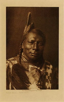 Edward S. Curtis - *50% OFF OPPORTUNITY* Flying Shield - Yanktonai - Vintage Photogravure - Volume, 12.5 x 9.5 inches - Born near Fort Berthhold, North Dakota, in 1856. He first went with a war-party against the Ute when he was fifteen years of age, on which occasion the Yanktonai brought back several horses. The next year he went against the Hidatsa with a party which took seven horses, and on several occasions Flying Shield captured horses for the Assiniboin. While with a party near Milk river he and another Yanktonai killed an entire Cree family in a solitary lodge, Flying Shield taking the man's scalp. He engaged in several horse-stealing expeditions against the Apsaroke and Nez Perces, and his war-honors were restricted chiefly to the capture of horses. His medicine consisted of a pipe and a wolf-skin. He married at twenty-one.
<br>
<br>Provenance: 
<br>Art Institute of Chicago, Ryerson & Burnham Library