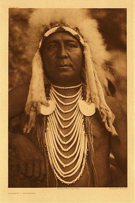 Edward S. Curtis -   Plate 139 Upshaw - Asparoke - Vintage Photogravure - Portfolio, 22 x 18 inches - With the money granted to him by J.P. Morgan for his North American Indian project, Curtis was able to employ Native American assistants to help him in the field. These assistants were interpreters, informants, and even friends. The most notable of his assistants was Alexander B. Upshaw a Crow Indian who had been well educated but had turned his back on “White” ways. <br><br>Upshaw was a tireless campaigner for Indian land rights and was much admired by his own people. He was employed by Curtis and worked with the project from 1905 until his death in 1909. He was essential in collecting ethnological data from members of a number of tribes, including the Sioux, Arikaras, and the Blackfeet. His hard work gained them access to ceremonies and more importantly helped with a thorough investigation of the Battle of the Little Bighorn.<br><br>Upshaw was an intelligent and trusted aide in the project, “In one sense Upshaw become more famous than any other member of the project except Curtis himself”, said Mick Gidley. It is safe to say, especially for the material on the Apsaroke and Hidatsa peoples, that Upshaw played a key role in Curtis’ ability to gain the relationships and acquire the knowledge he sought after.