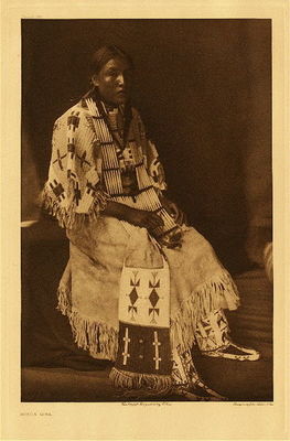 Edward S. Curtis -   Plate 097 Sioux Girl - Vintage Photogravure - Portfolio, 22 x 18 inches - A young Sioux woman in a dress made entirely of deerskin, embroidered with beads and porcupine-quills.<br><br>The decorative art of the Lakota found expression on their deerskin garments, pipe-bags, saddle-blankets, robes, parfleches, shields and tipis… There seems to be no fixed motif in many of their designs, each woman reading into her art whatever may be prompted by her thoughts, the same figure sometimes meaning as many different things as there are workers.