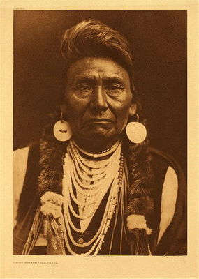 Edward S. Curtis -   Plate 256 Chief Joseph - Nez Perce - Vintage Photogravure - Portfolio, 22 x 18 inches - The man who became a national celebrity with the name "Chief Joseph" was born in the Wallowa Valley   in what is now northeastern Oregon in 1840. He was given the name  Hin-mah-too-yah-lat-kekt, or Thunder Rolling Down the Mountain, but was widely known as Joseph, or Joseph the  Younger, because his father had taken the Christian name Joseph when he was baptized at the Lapwai mission by Henry Spalding in 1838.<br>Joseph the Elder was one of the first Nez Percé converts to Christianity and an active supporter of the tribe's longstanding peace with whites. In 1855 he even helped Washington's territorial governor set up a Nez Percé reservation that stretched from Oregon into Idaho. But in 1863, following a gold rush into Nez Percé territory, the federal government took back almost six million acres of this land, restricting the Nez Percé to a reservation in Idaho that was only one tenth its prior size. Feeling himself betrayed, Joseph the Elder denounced the United States, destroyed his American flag and his Bible, and refused to move his band from the Wallowa Valley or sign the treaty that would make the new reservation boundaries official.<br>When his father died in 1871, Joseph was elected to succeed him. He inherited not only a name but a situation made increasingly volatile as white settlers continued to arrive in the Wallowa Valley. Joseph staunchly resisted all efforts to force his band onto the small Idaho reservation, and in 1873 a federal order to remove white settlers and let his people remain in the Wallowa Valley made it appear that he might be successful. But the federal government soon reversed itself, and in 1877 General Oliver Otis Howard threatened a cavalry attack to force Joseph's band and other hold-outs onto the reservation. Believing military resistance futile, Joseph reluctantly led his people toward Idaho.<br>Unfortunately, they never got there. About twenty young Nez Percé warriors, enraged at the loss of their homeland, staged a raid on nearby settlements and killed several whites. Immediately, the army began to pursue Joseph's band and the others who had not moved onto the reservation. Although he had opposed war, Joseph cast his lot with the war leaders.<br><br><br><br><br><br><br>What followed was one of the most brilliant military retreats in American history. Even the unsympathetic General William Techumseh Sherman could not help but be impressed with the 1,400 mile march, stating that "the Indians throughout displayed a courage and skill that elicited universal praise… [they] fought with almost scientific skill, using advance and rear guards, skirmish lines, and field fortifications." In over three months, the band of about 700, fewer than 200 of whom were warriors, fought 2,000 U.S. soldiers and Indian auxiliaries in four major battles and numerous skirmishes.<br>By the time he formally surrendered on October 5, 1877, Joseph was widely referred to in the American press as "the Red Napoleon." It is unlikely, however, that he played as critical a role in the Nez Percé's military feat as his legend suggests. He was never considered a war chief by his people, and even within the Wallowa band, it was Joseph's younger brother, Olikut, who led the warriors, while Joseph was responsible for guarding the camp. It appears, in fact, that Joseph opposed the decision to flee into Montana and seek aid from the Crows and that other chiefs – Looking Glass and some who had been killed before the surrender -- were the true strategists of the campaign. Nevertheless, Joseph's widely reprinted surrender speech has immortalized him as a military leader in American popular culture:<br>I am tired of fighting. Our chiefs are killed. Looking Glass is dead. Toohoolhoolzote is dead. The old men are all dead. It is the young men who say, "Yes" or "No." He who led the young men [Olikut] is dead. It is cold, and we have no blankets. The little children are freezing to death. My people, some of them, have run away to the hills, and have no blankets, no food. No one knows where they are -- perhaps freezing to death. I want to have time to look for my children, and see how many of them I can find. Maybe I shall find them among the dead. Hear me, my chiefs! I am tired. My heart is sick and sad. From where the sun now stands I will fight no more forever.<br>Joseph's fame did him little good. Although he had surrendered with the understanding that he would be allowed to return home, Joseph and his people were instead taken first to eastern Kansas and then to a reservation in Indian Territory (present-day Oklahoma) where many of them died of epidemic diseases. Although he was allowed to visit Washington, D.C., in 1879 to plead his case to U.S. President Rutherford B. Hayes, it was not until 1885 that Joseph and the other refugees were returned to the Pacific Northwest. Even then, half, including Joseph, were taken to a non-Nez Percé reservation in northern Washington, separated from the rest of their people in Idaho and their homeland in the Wallowa Valley.<br>In his last years, Joseph spoke eloquently against the injustice of United States policy toward his people and held out the hope that America's promise of freedom and equality might one day be fulfilled for Native Americans as well. An indomitable voice of conscience for the West, he died in 1904, still in exile from his homeland, according to his doctor "of a broken heart."