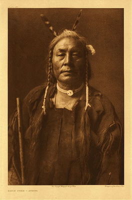 Edward S. Curtis -  *40% OFF OPPORTUNITY* Plate 168 Eagle Child – Atsina - Vintage Photogravure - Portfolio, 22 x 18 inches - Born in 1862, east of the Little Rockies. He first followed the war-path when twenty years of age, but gained no honors on this occasion. His next experience was in an expedition against the Piegan. Three of the enemy charged a small party of the Atsina, and one, singling him out, came so close that when the Piegan shot, the powder burned Eagle Child. Another Atsina shot the Piegan, and Eagle Child counted second coup and took the scalp.