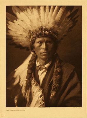 Edward S. Curtis -   Plate 021 Chief Garfield – Jicarilla - Vintage Photogravure - Portfolio, 22 x 18 inches - Some years ago the Jicarillas were all officially given Spanish or English names. Many of them expressed a preference. This old man, who was head-chief of the tribe at the time, selected the designation Garfield.<br><br>The Jicarillas, or as they are commonly called Jicarilla Apaches, occupy a reservation of nearly four hundred and fifty square miles of mountainous country in northern New Mexico. Linguistically the Jicarillas are the same stock as the Apaches of Arizona; but here the relationship ceases, for the two peoples have virtually no knowledge one for the other; each according to their respective genesis myths, had their origin in the general region in which they live to-day, while the dialect, mythology, legends, and medicine rites of the Jicarillas more closely resemble those of the Navaho than any of the Apache groups.