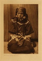 Edward S. Curtis -  *40% OFF OPPORTUNITY* Touch Her Dress - Kalispel - Vintage Photogravure - Volume, 12.5 x 9.5 inches - Photographed by Edward S. Curtis, “Touch Her Dress” pictures a young woman of the Kalispel tribe. She is posing for the camera wearing a traditional elk tooth dress as well as jewelry.<br><br>This image was taken in 1910 by photographer Edward S. Curtis and was printed on Dutch Van Gelder. The Original photogravure is available for sale in our Aspen Art Gallery.