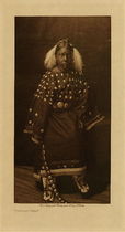 Edward S. Curtis -   Ogalala Child - Vintage Photogravure - Volume, 12.5 x 9.5 inches - When a young woman gave her consent to marry her relatives would bring to her an elk-toothed dress, beaded moccasins, and leggings all of the things considered necessary for a married woman. The young Ogalala girl pictured here by Edward Curtis is wearing an example of the elk toothed dress and beaded moccasins that showed wealth and status in her tribe.<br><br> This photogravure was taken in 1907 by Edward S. Curtis. The piece was printed on Dutch Van Gelder and is available for sale in out Aspen Art Gallery.<br><br>Provenance: Original Subscription Set #59. George D. Barron, Rye, NY