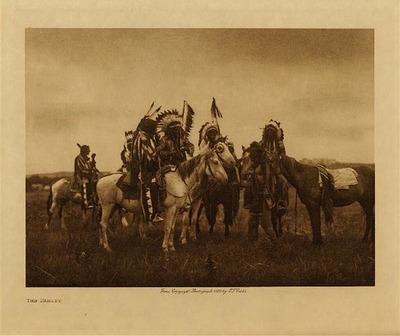 Edward S. Curtis -   The Parley - Vintage Photogravure - Volume, 9.5 x 12.5 inches - "A 'coup' could be won by actually killing an enemy, by striking the body of an enemy whether dead or alive, by capturing a horse or a band of horses, or by taking a scalp. Honors were counted on each hostile warrior by the first four who struck him, the first in each case winning the greatest renown, an honor called 'taya-kte' (kill right). Thus if twenty men were struck or even touched in an encounter, twenty honors of the first grade were won by the victors. But the greatest exploit of all was to ride in the midst of the enemy and strike a warrior in action without attempting to wound him. When a man had lead four war parties, and in each achieved a first honor, he was eligible to chiefmanship." by Edward S. Curtis in "The North American Indian," Volume III<br><br>Provenance: <br>Art Institute of Chicago, Ryerson & Burnham Library