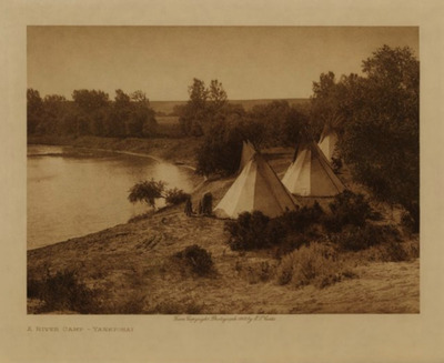 Edward S. Curtis - A River Camp - Yanktonai - Vintage Photogravure - Volume, 9.5 x 12.5 inches - A beautiful Yanktonai camp along the river bend is pictured in this photogravure by Edward S. Curtis. Three tipis are visible tucked into the trees and shrubs surrounding the waterway. There are a few Natives around the camp preforming tasks and youngsters watching. This image was taken by Curtis in 1908 and is on display at our Aspen Art Gallery. <br> <br>The Yanktonai had five principal religious rites "Sun Dance," "Vision Cry," Ghost Keeper," "Buffalo Chant" (puberty), and "Foster-parent Chant", similar to the Tetons, but did not include "White Buffalo Woman." The Assiniboin venerated Thunder and Sun and "Anu k-ite" (Double Face), vaguely described as a spirit which appeared to devotees in the Sun Dance, and told them he was searching for those who did not make sacrifice to him. - Edward Curtis <br> <br>Provenance: <br>Art Institute of Chicago, Ryerson & Burnham Library